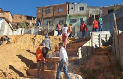 Moradores, voluntários e funcionários da PBH subindo escadas nas obras de área de risco da Vila Pedreiro Prado Lopes.